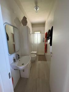 a white bathroom with a sink and a toilet at Villa BeaBella in Scicli