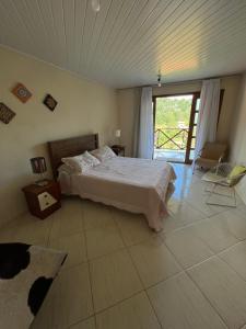 a bedroom with a bed and a large window at Chalé Vista Azul in Domingos Martins