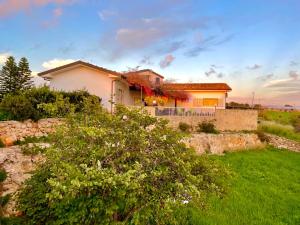 una casa sentada en la cima de un campo verde en Villa BeaBella en Scicli