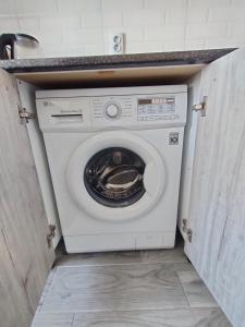 a white washing machine in a cabinet in a kitchen at ЖК Наурыз парк in Shymkent