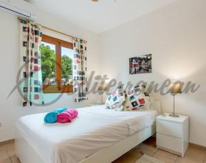 a bedroom with a white bed and a window at Villa Casablanca near port adriano by villasmediterranean in El Toro