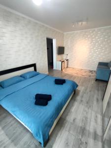 sypialnia z niebieskim łóżkiem i niebieskim krzesłem w obiekcie ЖК Наурыз парк w mieście Szymkent