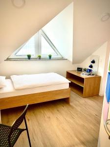 Schlafzimmer mit einem Bett, einem Schreibtisch und einem Fenster in der Unterkunft Rainbow House Rooms in Maribor