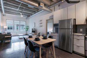 a kitchen with a table and a stainless steel refrigerator at Stylish City Living Apartments with Free Parking in Midtown Atlanta in Atlanta