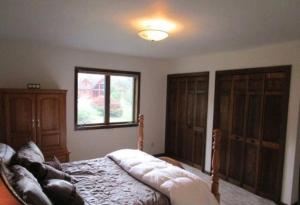 a bedroom with a bed and some wooden cabinets at Mountain view apartment, 5mins to Ski Area! in Windham
