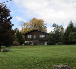 a house in a field with a green yard at Mountain view apartment, 5mins to Ski Area! in Windham