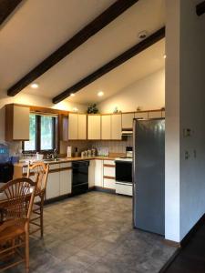 a kitchen with white cabinets and a stainless steel refrigerator at Mountain view apartment, 5mins to Ski Area! in Windham