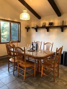 a dining room with a wooden table and chairs at Mountain view apartment, 5mins to Ski Area! in Windham +8 photos