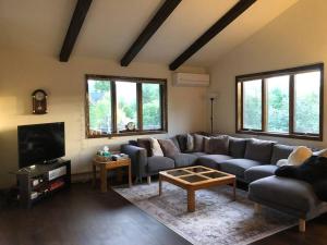 a living room with a couch and a tv at Mountain view apartment, 5mins to Ski Area! in Windham