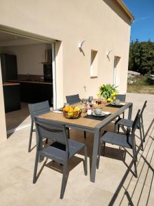einen Tisch und Stühle mit einer Obstschale auf der Terrasse in der Unterkunft Casa voscia in Casalabriva
