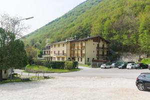 a large building with cars parked in a parking lot at Albergo Dalla Mena in Romano D'Ezzelino