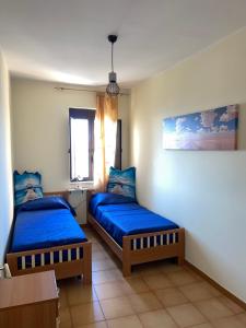 2 Betten in einem Zimmer mit blauer Bettwäsche in der Unterkunft Vista mare center apartment in Tropea