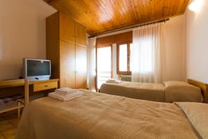 a hotel room with two beds and a television at Albergo Dalla Mena in Romano D'Ezzelino