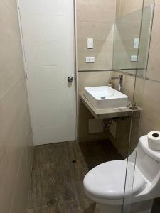 a bathroom with a white toilet and a sink at Apartamento Completo, cerca a Mall Aventura Plaza in Trujillo