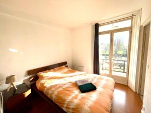 a bedroom with a bed and a large window at Escapade Morétaine - La Halte Intemporelle in Moret-sur-Loing