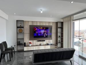 a living room with a flat screen tv on a wall at Apartamento Completo, cerca a Mall Aventura Plaza in Trujillo