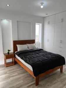 a bedroom with a large bed with white cabinets at Apartamento Completo, cerca a Mall Aventura Plaza in Trujillo
