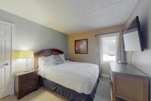 a bedroom with a bed and a desk and a television at Wintergreen 125 in Blue Mountains