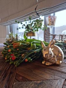 a table with a bunny and flowers on it at Apartament Prestige & Sea Balticus A4 in Międzyzdroje