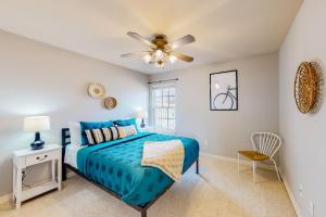 a bedroom with a blue bed and a ceiling fan at The Brick Beauty on Cabriolet in Bentonville