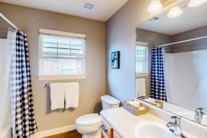 a bathroom with a sink toilet and a mirror at The Brick Beauty on Cabriolet in Bentonville +25 photos