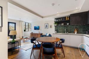 a kitchen and living room with a table and chairs at Stylish & Modern 1BR in Islington! in London