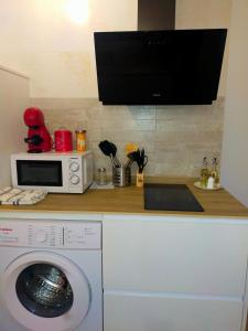 a kitchen with a washing machine and a microwave at La Tahona de Almarza in Almarza