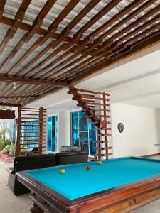 una mesa de billar en una sala de estar con techo de madera en Hotel Zensi 420, en Lejanías