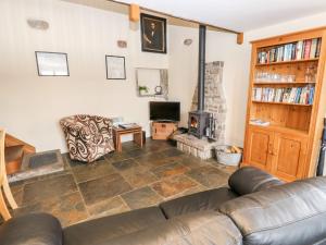 a living room with a couch and a fireplace at The Hay Barn in Disley