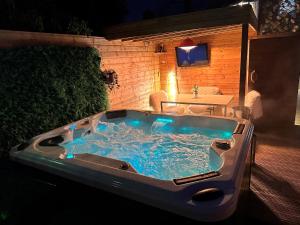 a jacuzzi tub in a backyard at night at Achill Guest House in Solihull