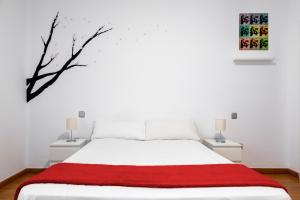 1 dormitorio con cama blanca y manta roja en Monrooms Barcelona, en Barcelona