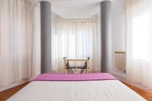 1 dormitorio con 1 cama grande y 1 mesa en Monrooms Barcelona, en Barcelona