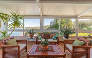 eine abgeschirmte Veranda mit Stühlen, Tischen und Pflanzen in der Unterkunft Casa Mirador de la Estrella 