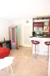eine Küche und ein Wohnzimmer mit einem roten Sofa und einem Stuhl in der Unterkunft Maldives YourHostHelper in Saint-Cyr-sur-Mer