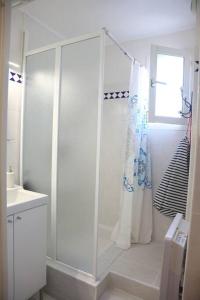 ein weißes Bad mit einer Dusche und einem Waschbecken in der Unterkunft Maldives YourHostHelper in Saint-Cyr-sur-Mer