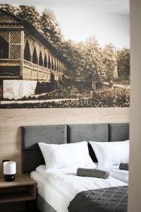 sypialnia z łóżkiem z obrazem na ścianie w obiekcie Pensjonat Zdrojowy Apartamenty w Rabce