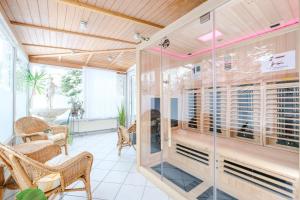 a glass room with a table and chairs at Hotel Paidion in Braunlage