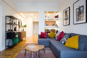 a living room with a blue couch with colorful pillows at Athena’s Hideaway- Fully Renovated- Absolute Best Location in Athens