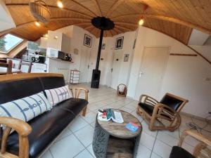 a living room with a couch and a table at Les Dômes du Ponant in Plouguerneau +3 photos