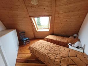 a bedroom with two beds in a wooden cabin at Les Dômes du Ponant in Plouguerneau