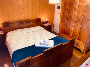 Appartamento Asiago - Residence Grassana - a pochi passi dal centro في أسياجو: غرفة نوم مع سرير مع قبعة عليه