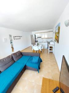 salon z niebieską kanapą i kuchnią w obiekcie Casa DamiAnna - Pool - WiFi - FuerteventuraBay w mieście Costa de Antigua
