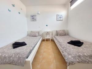 2 łóżka pojedyncze w pokoju ze stołem w obiekcie Casa DamiAnna - Pool - WiFi - FuerteventuraBay w mieście Costa de Antigua +23 zdjęcia