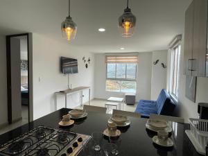 una cucina e un soggiorno con tavolo e piano cottura di Trip Monkey Apartments a San Gil