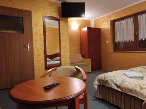 ein Hotelzimmer mit einem Bett, einem Tisch und einem Stuhl in der Unterkunft Agroturystyka Kameralna93 in Ochaby