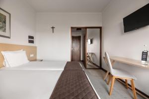 a bedroom with a bed and a desk and a chair at Crisol Tres Pastorinhos in Fátima