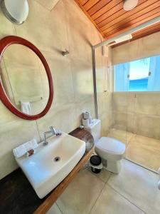 uma casa de banho com um lavatório, um WC e um espelho. em Orlanova Hotel em Arraial do Cabo