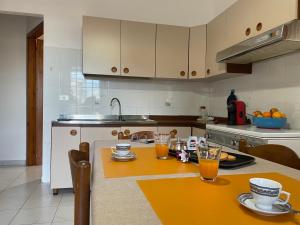 una cocina con mesa y 2 vasos de zumo de naranja en Da Mamma IUN Q9152, en Santa Maria Navarrese