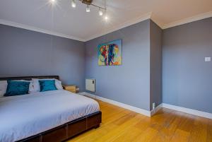a bedroom with a bed and a painting on the wall at Statera Apartments - Thames View in London