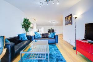 a living room with a couch and a tv at Statera Apartments - Thames View in London